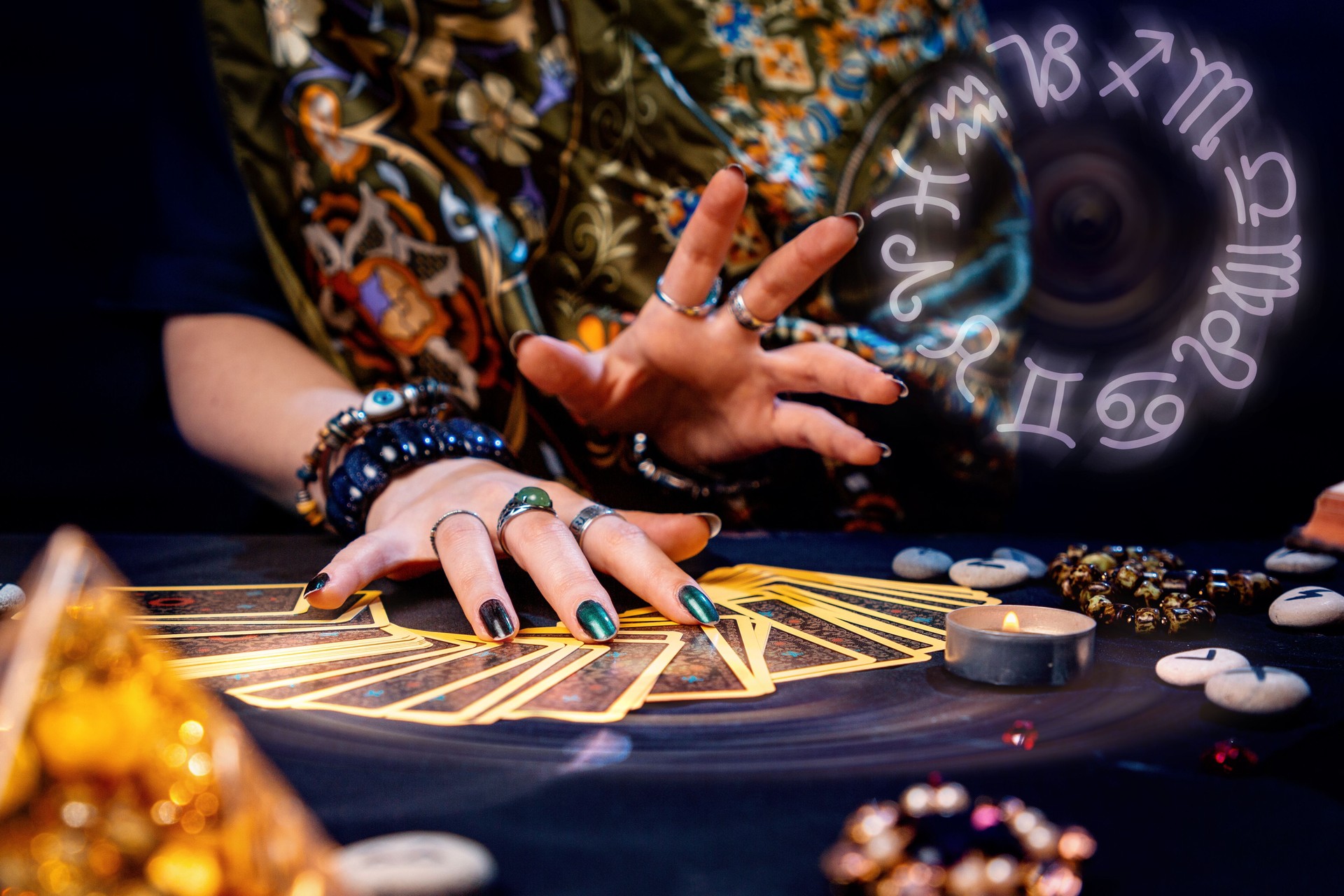 A witch spread out her tarot cards on the table. Hands close-up. The zodiac circle in the upper right corner. The concept of divination and astrology