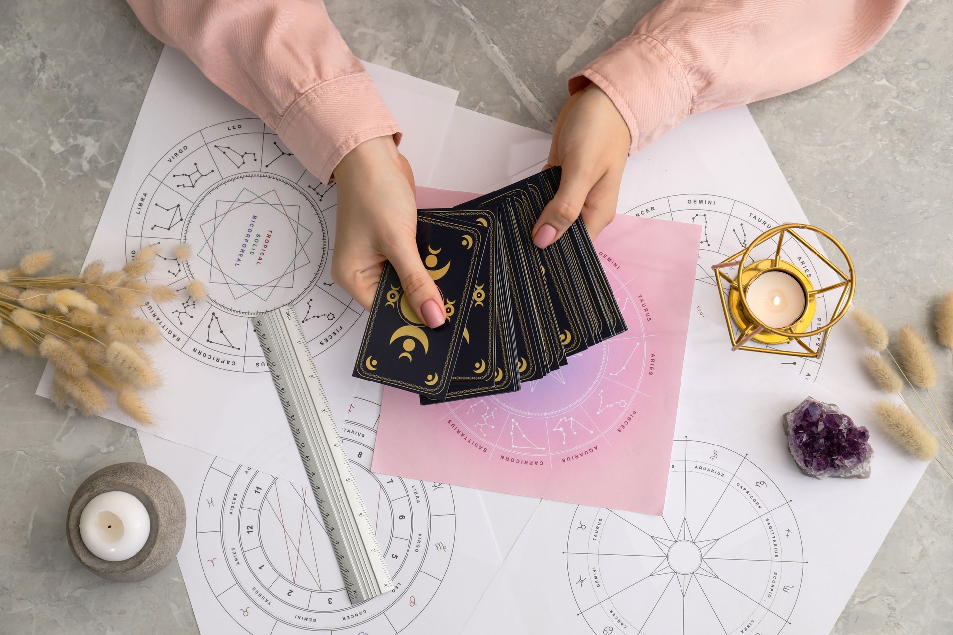 Woman using tarot cards at table, top view. Astrological predictions